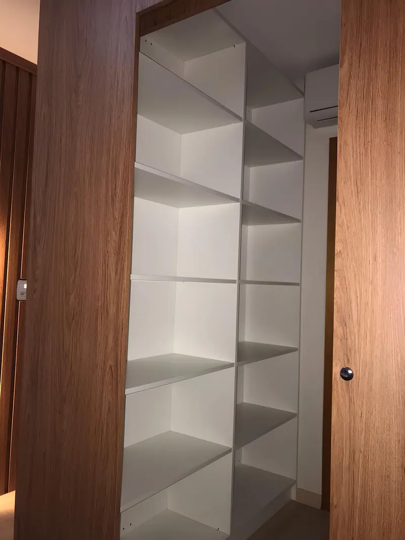 Closet com prateleiras brancas e laterais em madeira